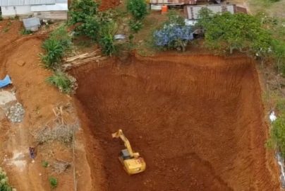 Foto udara aktivitas alat berat di area galian tanah dekat permukiman warga di Desa Torobulu, Konawe Selatan.