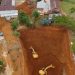 Foto udara aktivitas alat berat di area galian tanah dekat permukiman warga di Desa Torobulu, Konawe Selatan.