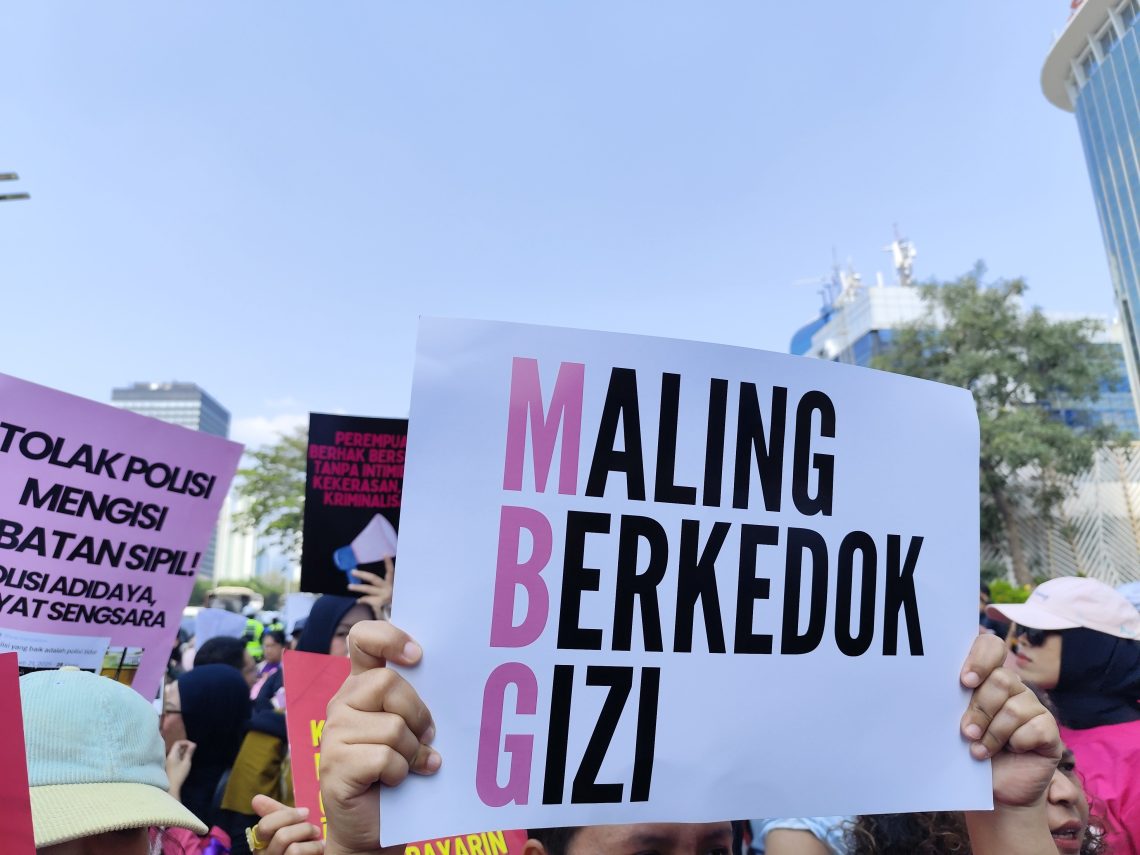 Peserta aksi Aliansi Perempuan Indonesia (API) mengangkat poster bertuliskan "Maling Berkedok Gizi" saat demonstrasi di kawasan Jakarta Pusat, Kamis (18/6/2026). Aksi tersebut menyuarakan berbagai tuntutan terkait kondisi ekonomi dan kebijakan pemerintah.