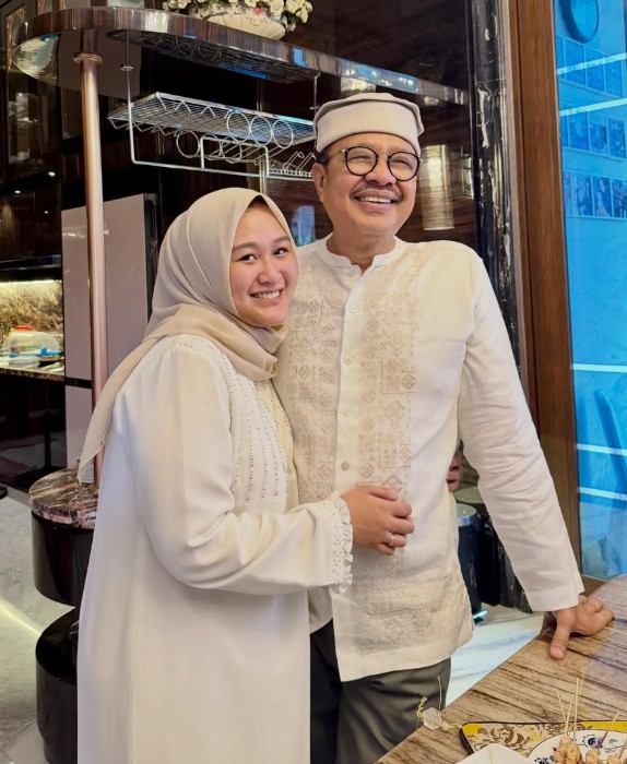 Mantan Gubernur Sulawesi Tenggara, Nur Alam, berfoto bersama seorang anggota keluarga dengan busana bernuansa putih di sebuah ruangan, di tengah kabar bergabungnya dirinya dengan Partai Solidaritas Indonesia (PSI).