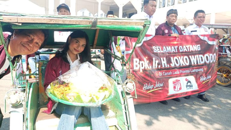 Relawan Bara JP dan kader muda PSI membawa tumpeng di atas becak saat menyambut kedatangan Presiden ke-7 RI Joko Widodo di Bandar Lampung dalam rangka perayaan ulang tahun ke-65.