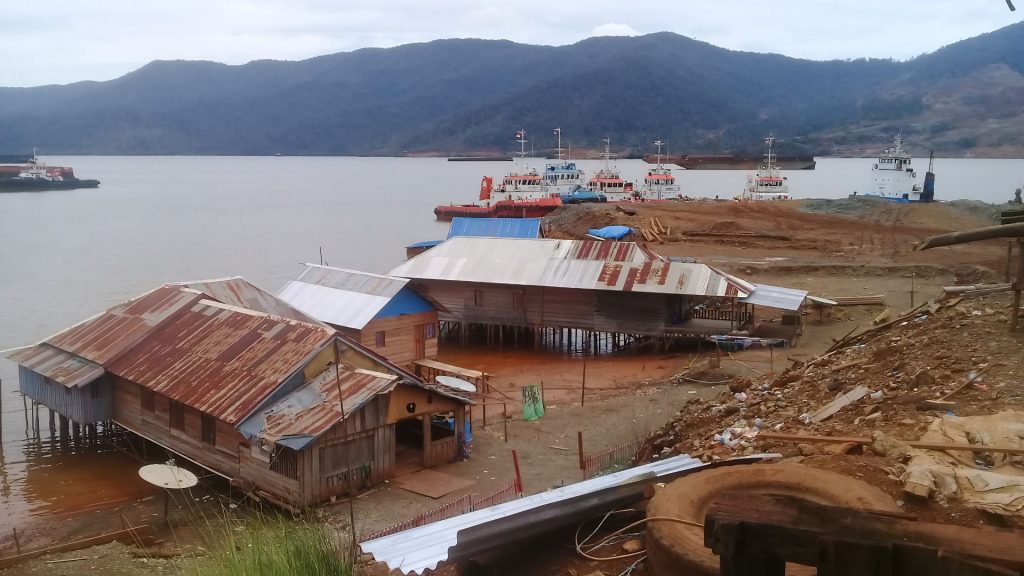 Sejumlah tugboat dan tongkang terparkir di jetty pengangkutan ore nikel yang berada di sekitar kawasan permukiman masyarakat Bajo Marombo Pantai, Konawe Utara.
